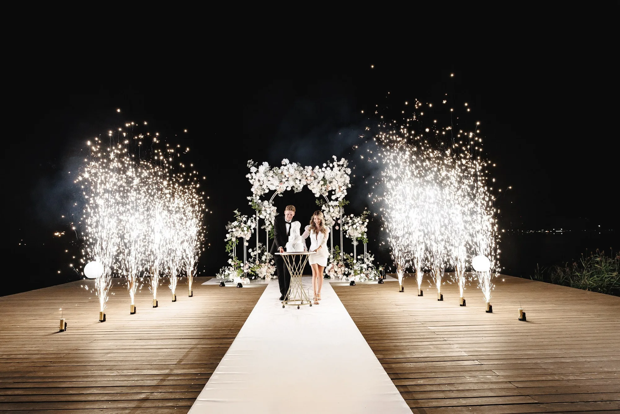 Egor and Ekaterina celebrating their wedding beneath sparkling fountains